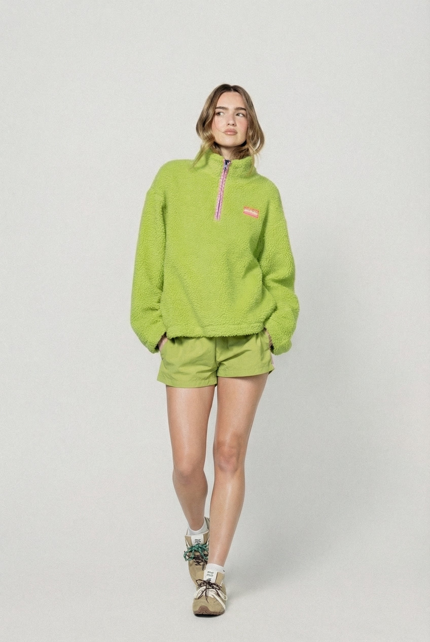 Person wearing a bright green fleece outfit on a white background |m1