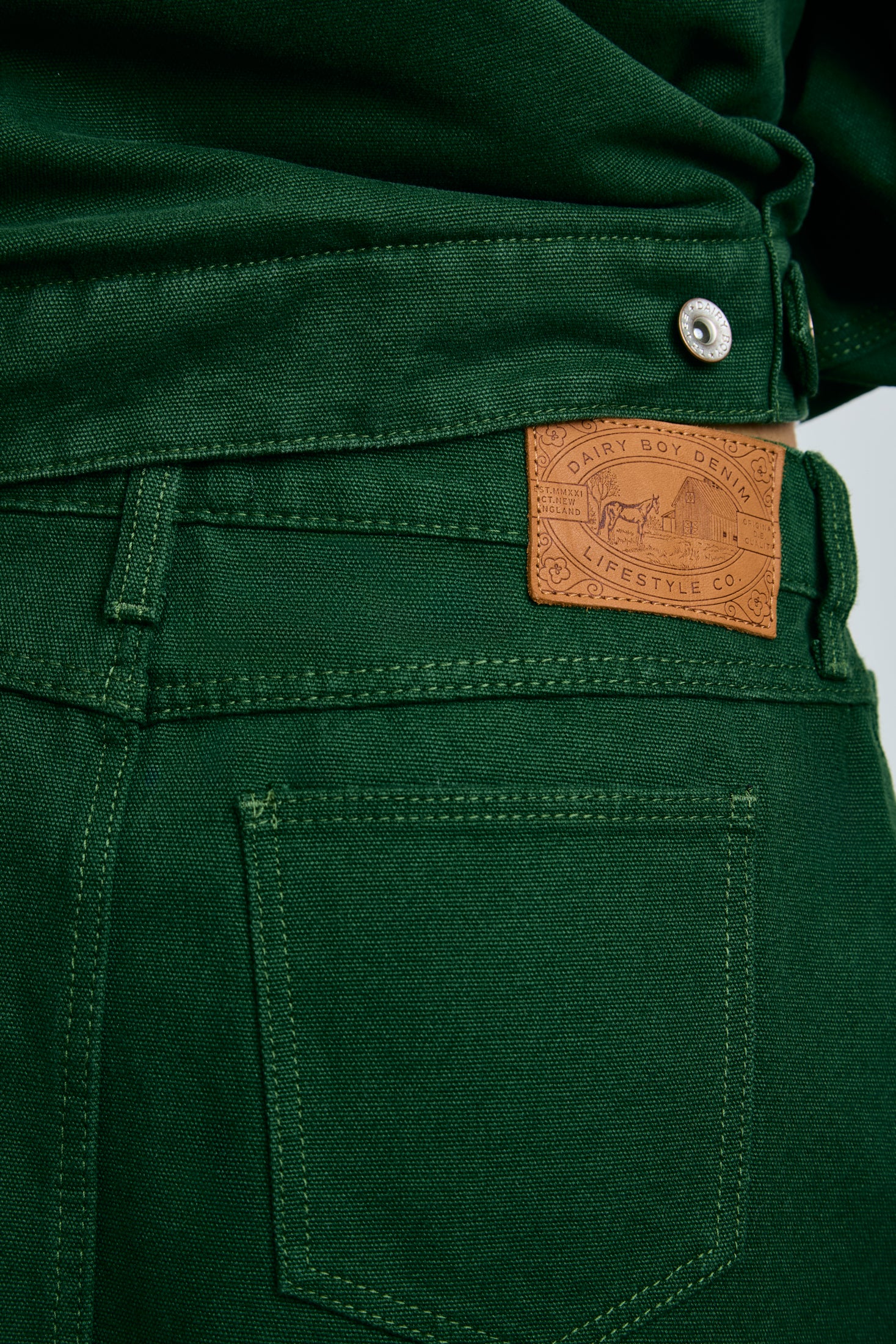 Close-up of green pants with a brand label on a gray background |m1