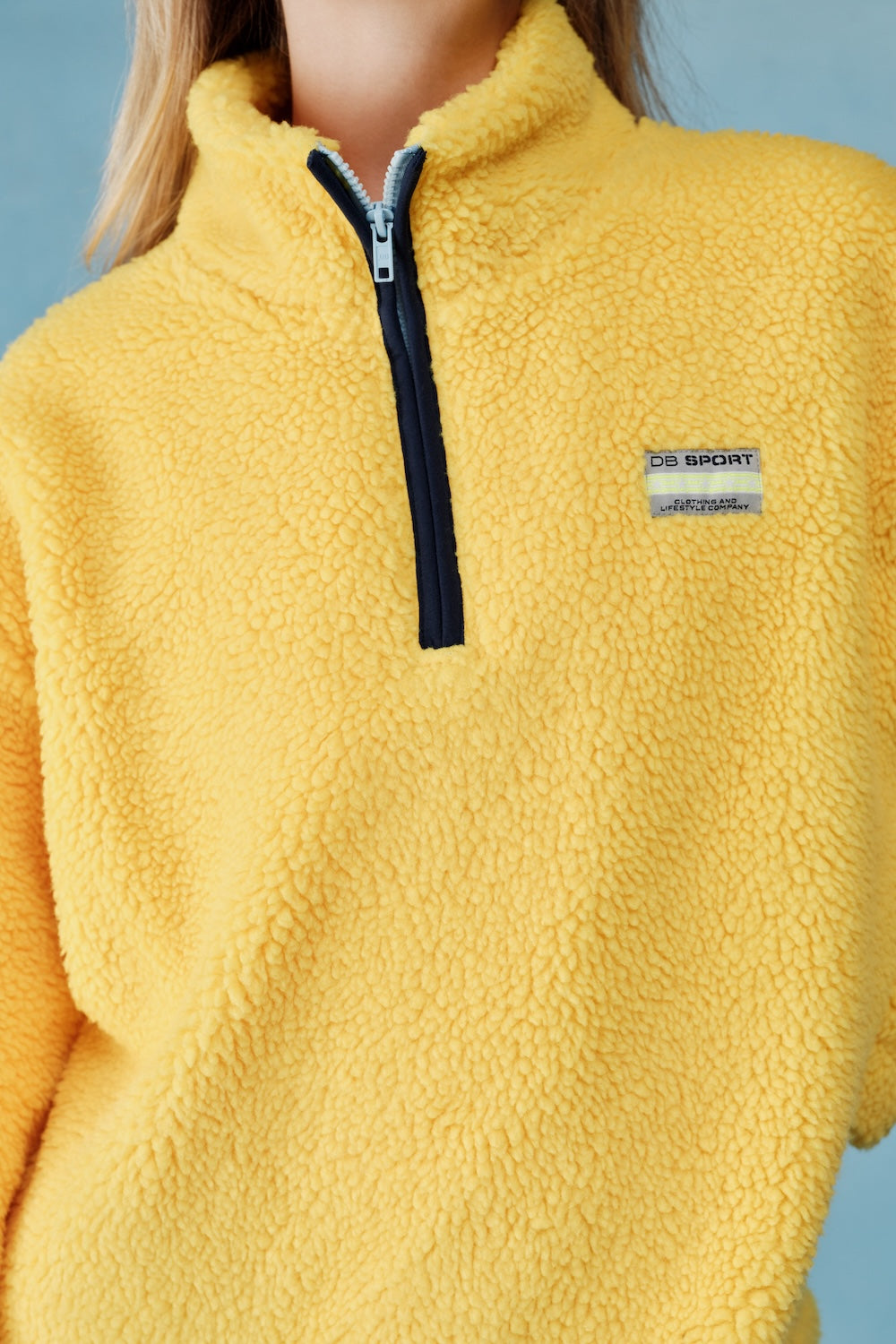 Yellow fleece pullover with a brand logo on a gray background |M1