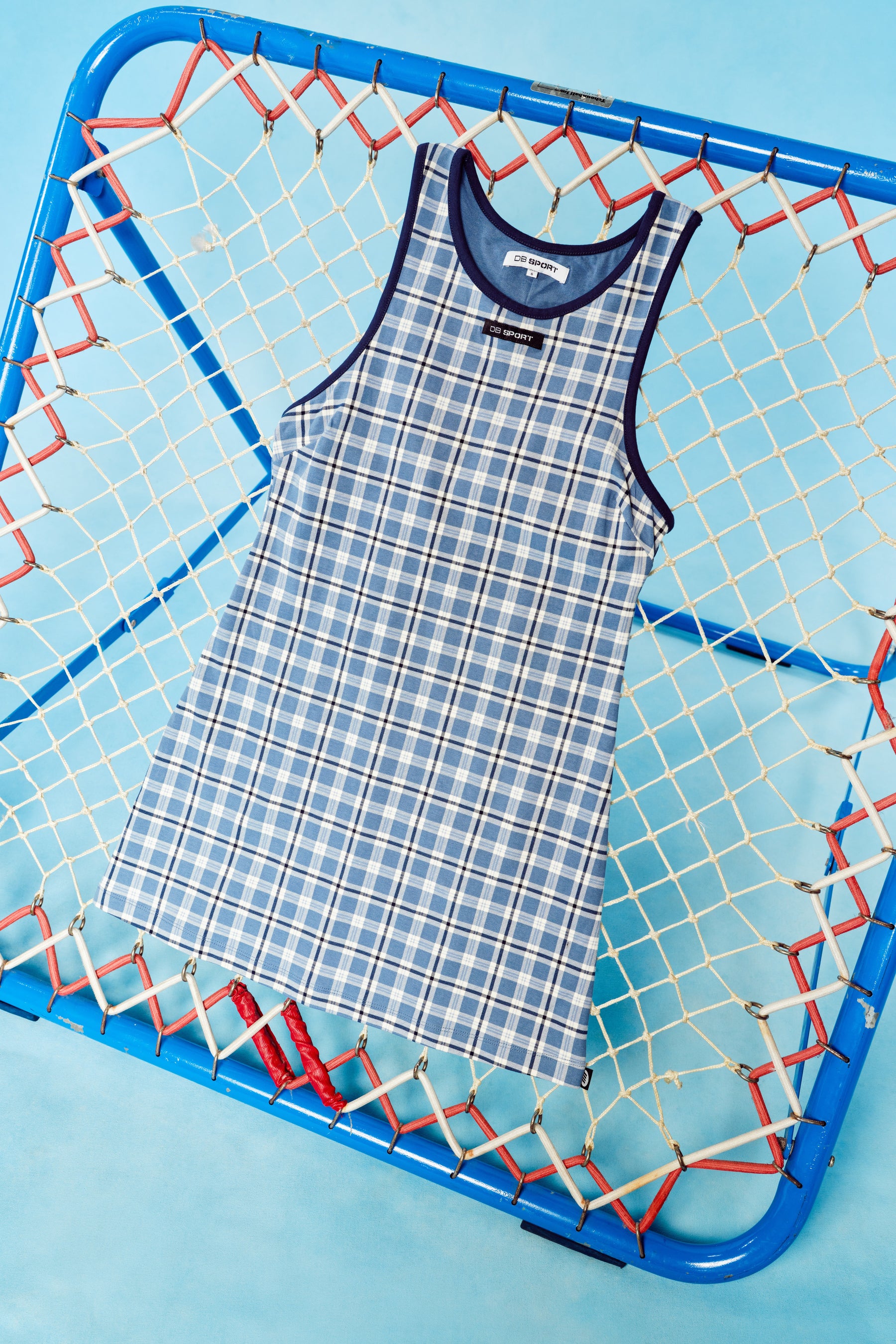Blue and white checkered dress on a blue background with a sports net