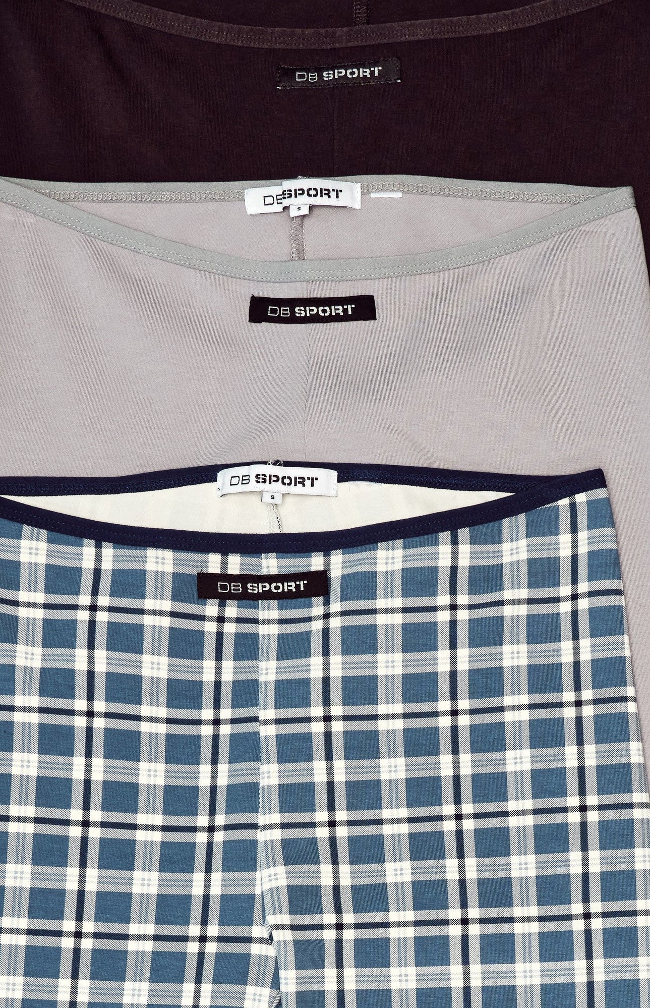 Three pairs of capris in plaid and solid colors on a light blue background