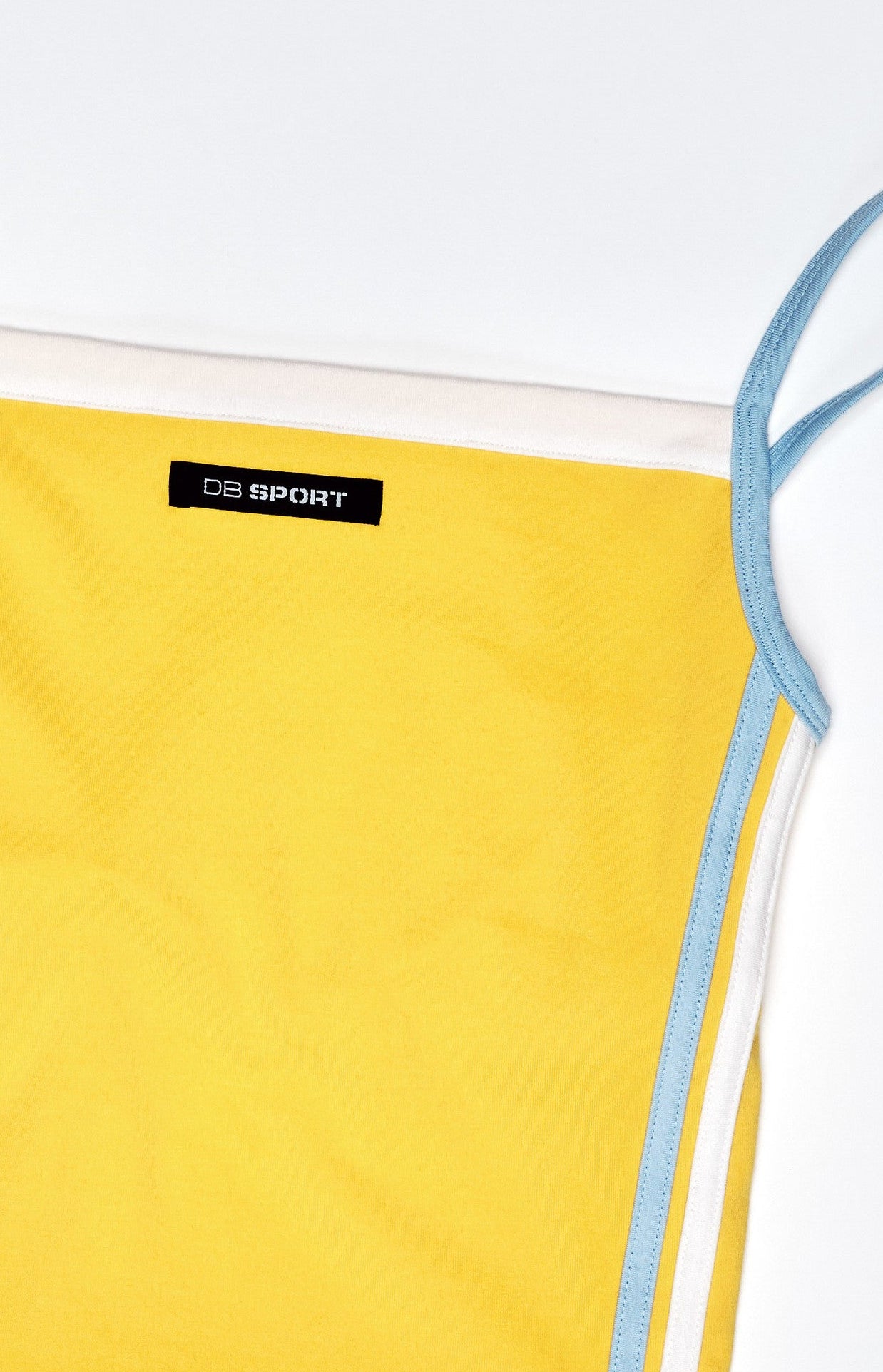 Yellow tank top with thin straps on a light gray background