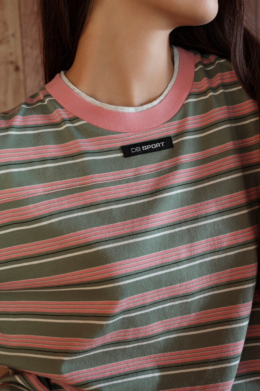 Close-up of a striped shirt with a brand label on a model
|M1