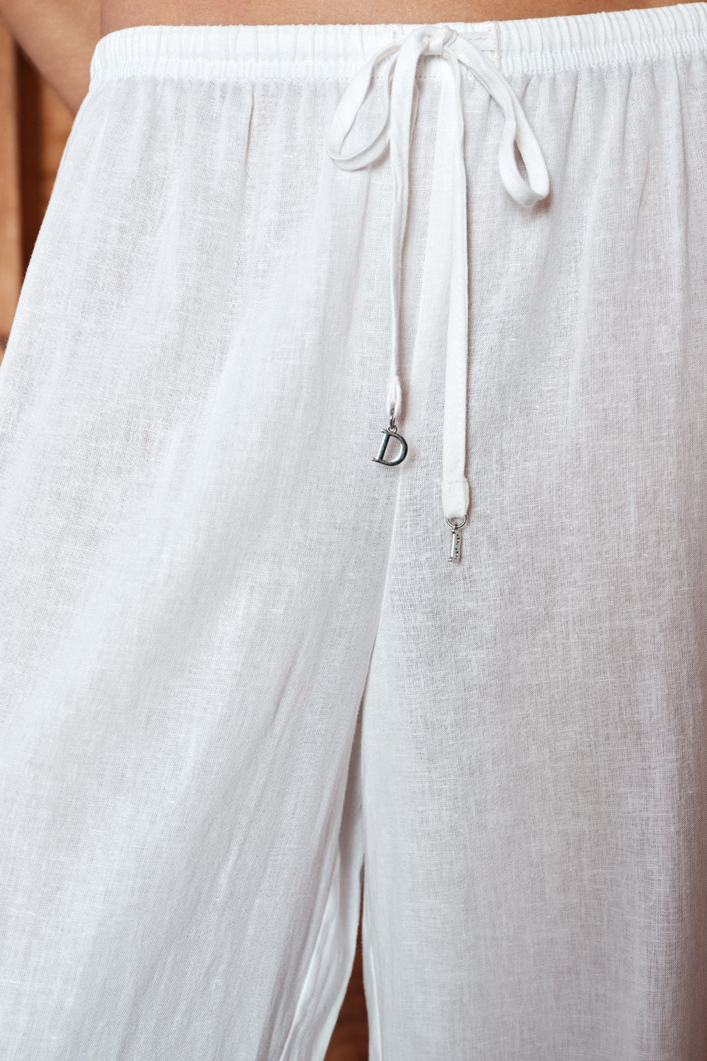 White pants with a drawstring and brand logo on a plain background
|M1