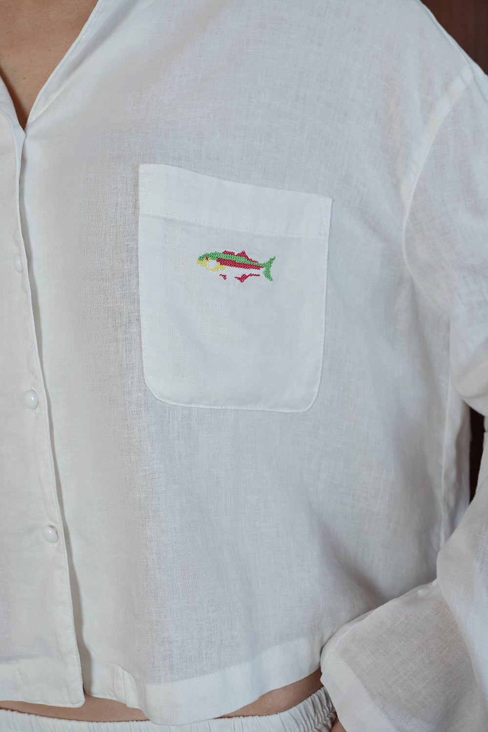 White shirt with a colorful fish design on the chest pocket
|M1