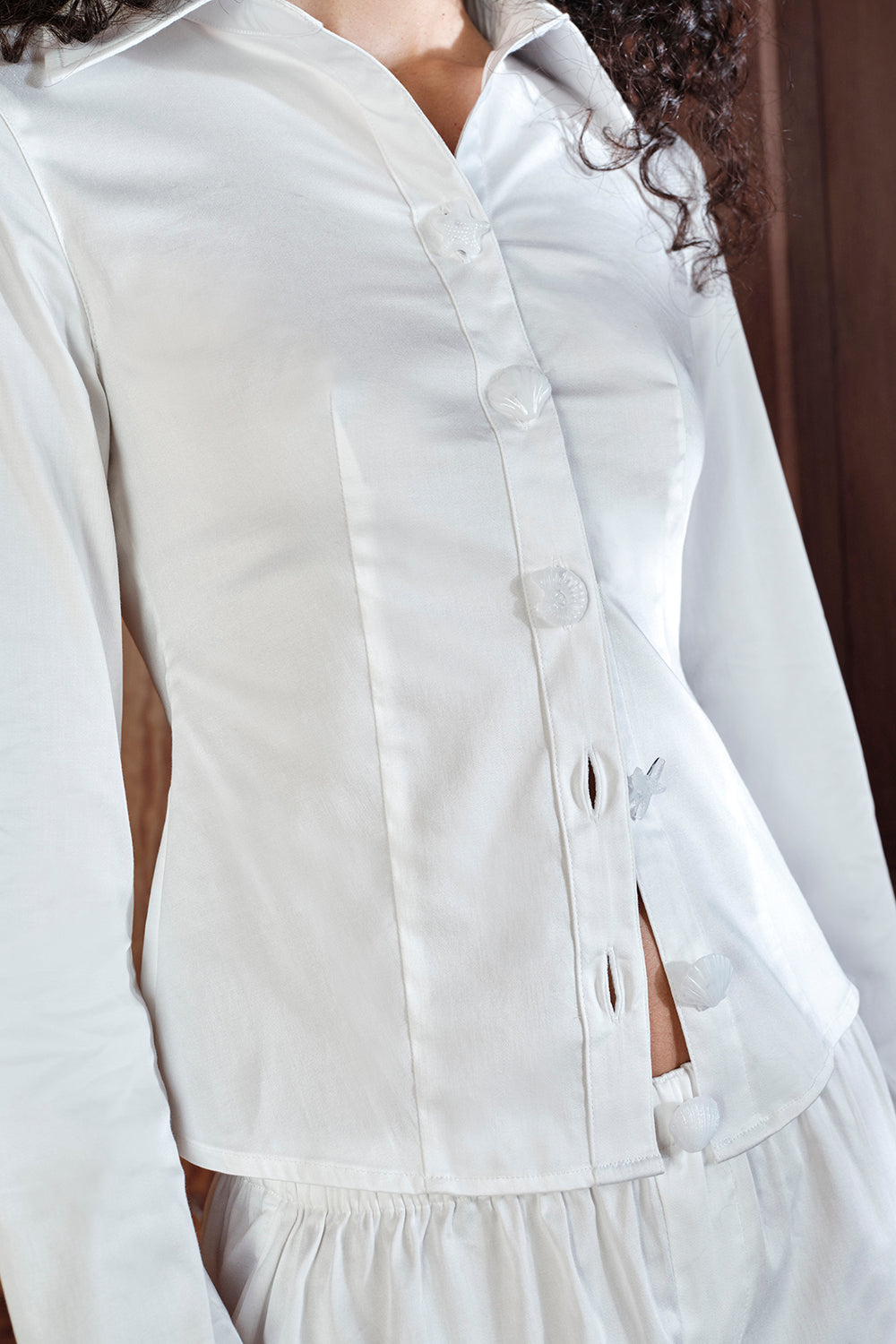 Close-up of a white button-up shirt with a blurred background
|M1