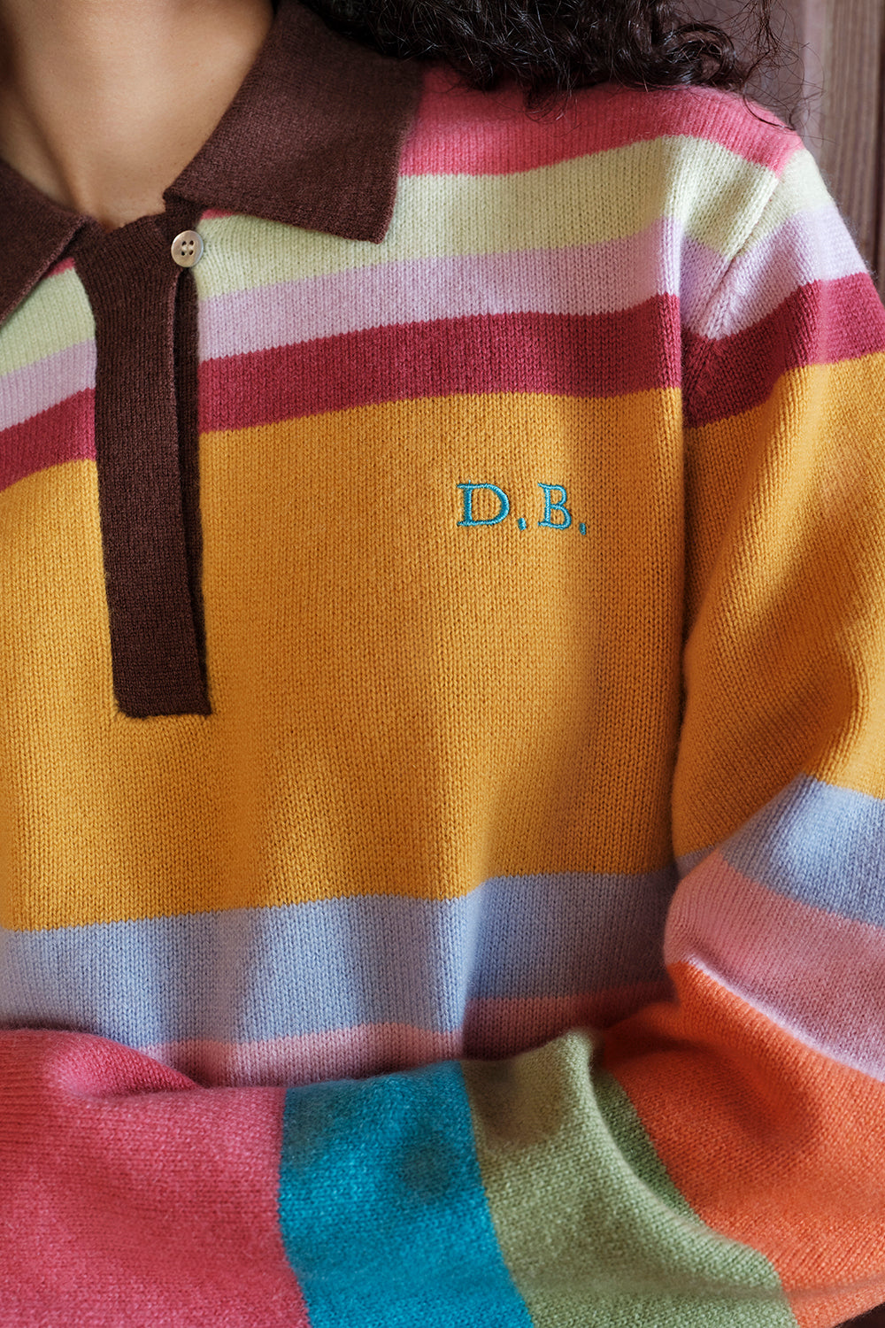 Multicolored striped sweater with 'D.B.' logo on chest
|M1