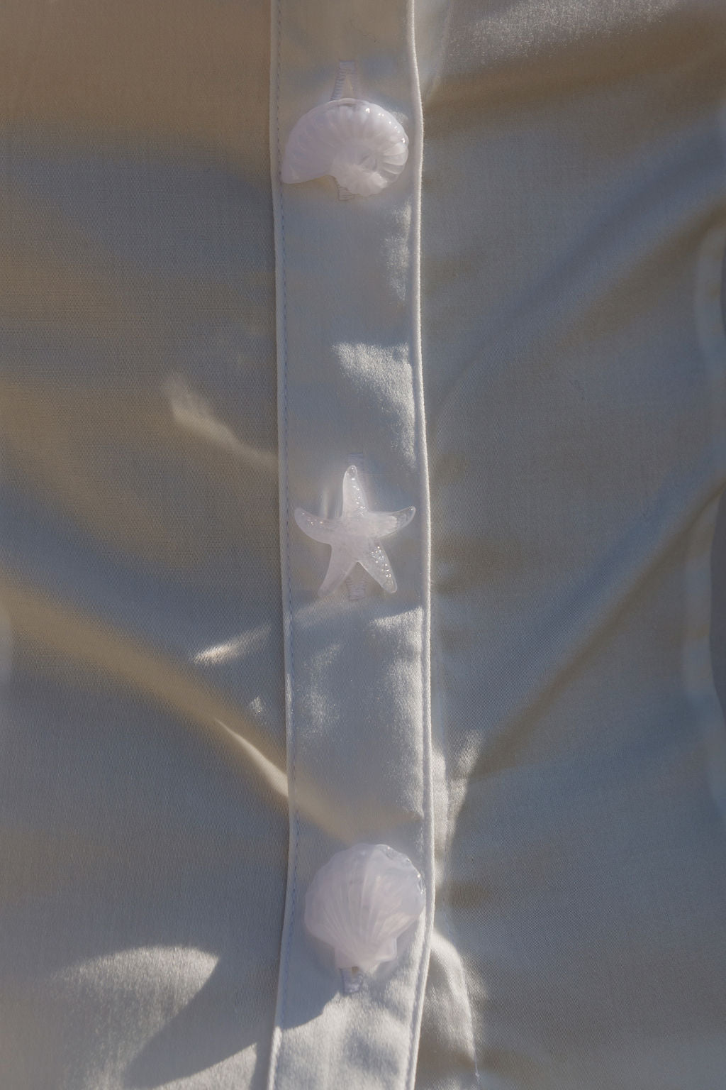 white button up with detailed image of shell buttons