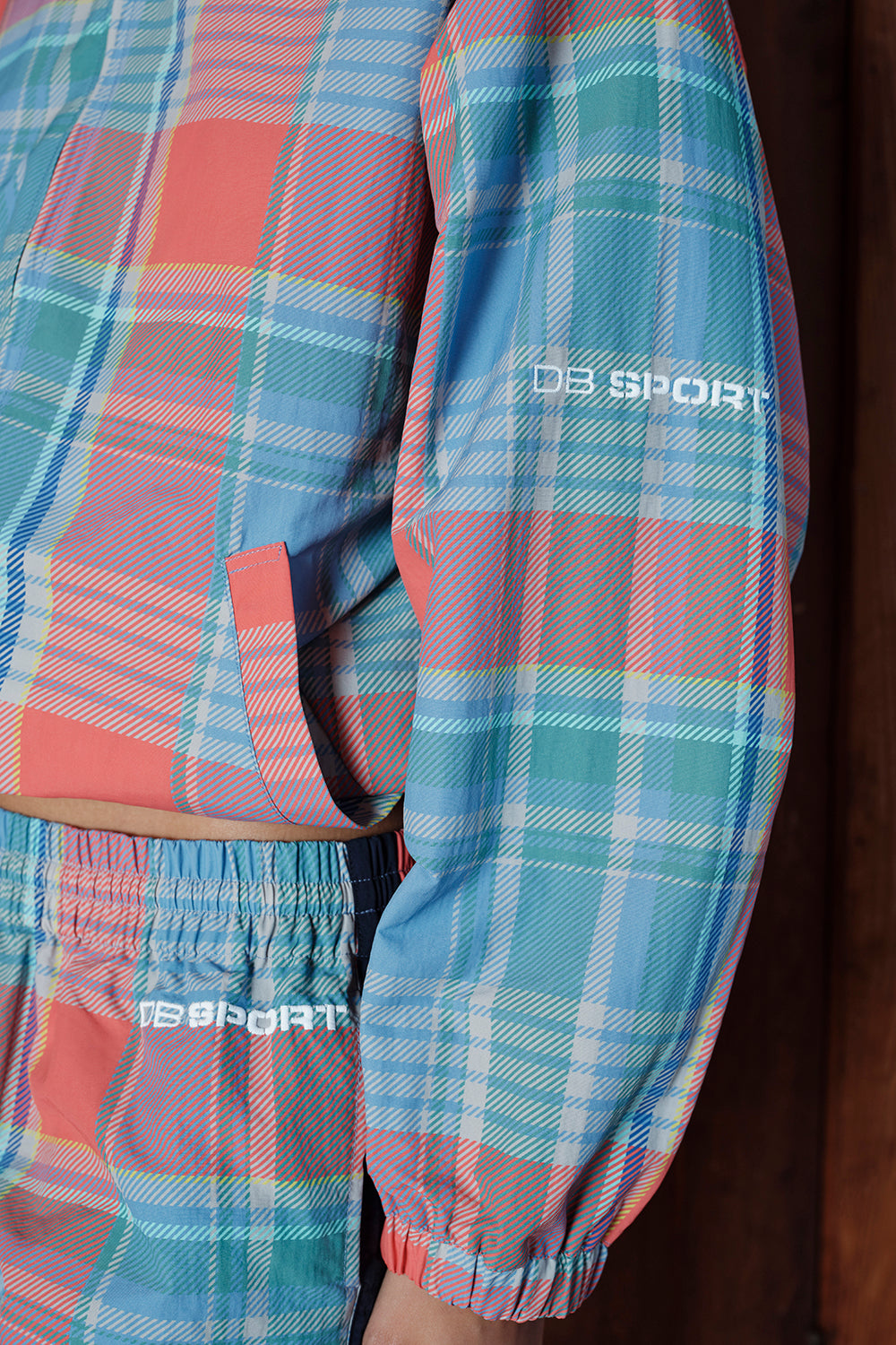 Plaid jacket with 'DB Sport' branding on a wooden surface
|M1