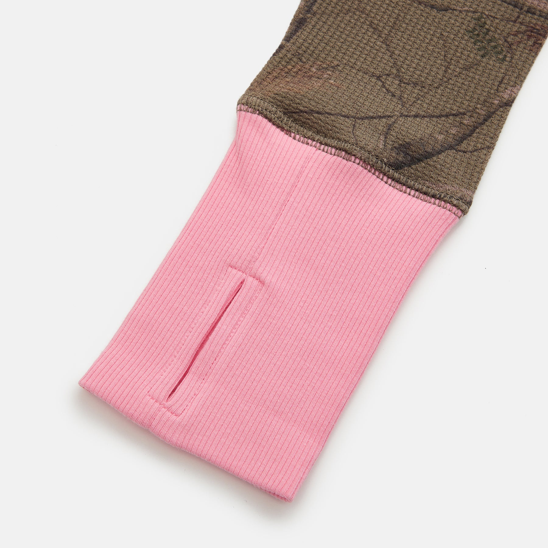 Close-up of a pink and camo fabric with a pocket on a white background