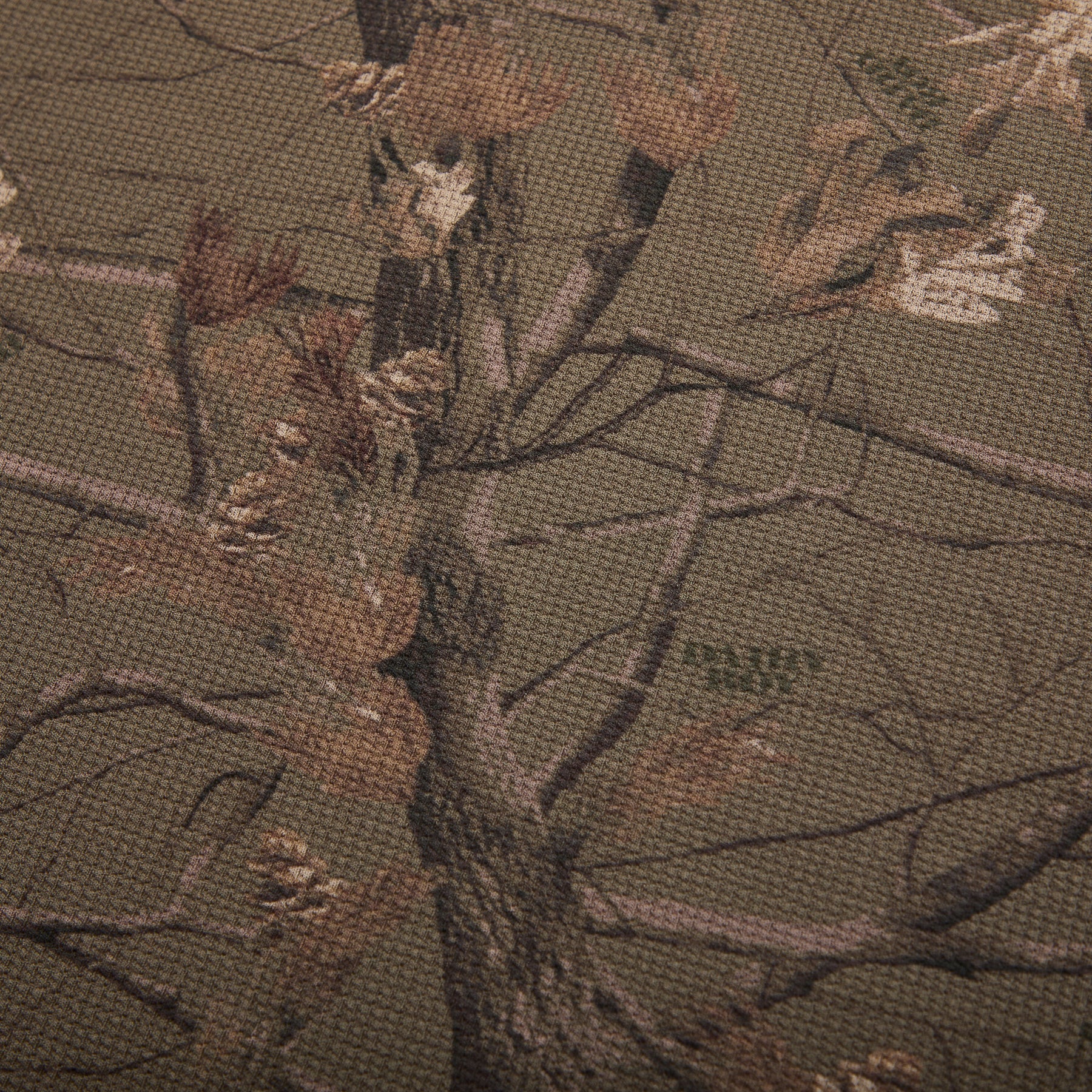 Close-up of camouflage fabric with a tree pattern and 'dairy boy' branding.