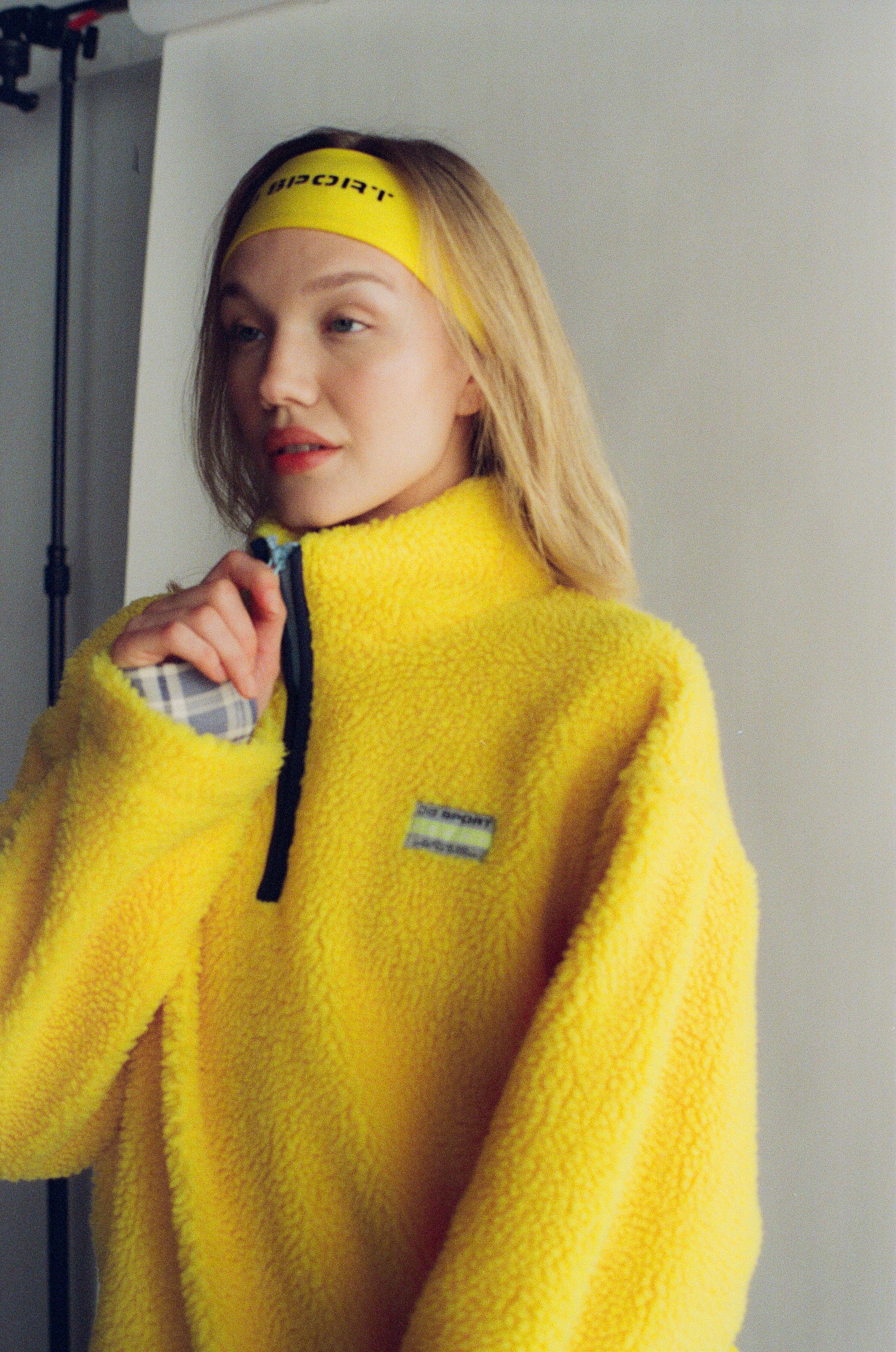 Person wearing a yellow fleece pullover with a visible brand logo, standing against a plain background. |M1