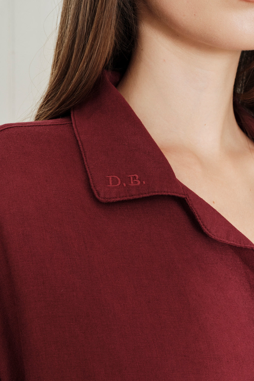 Close-up of a maroon shirt with 'D.B.' embroidery on the collar. |M1