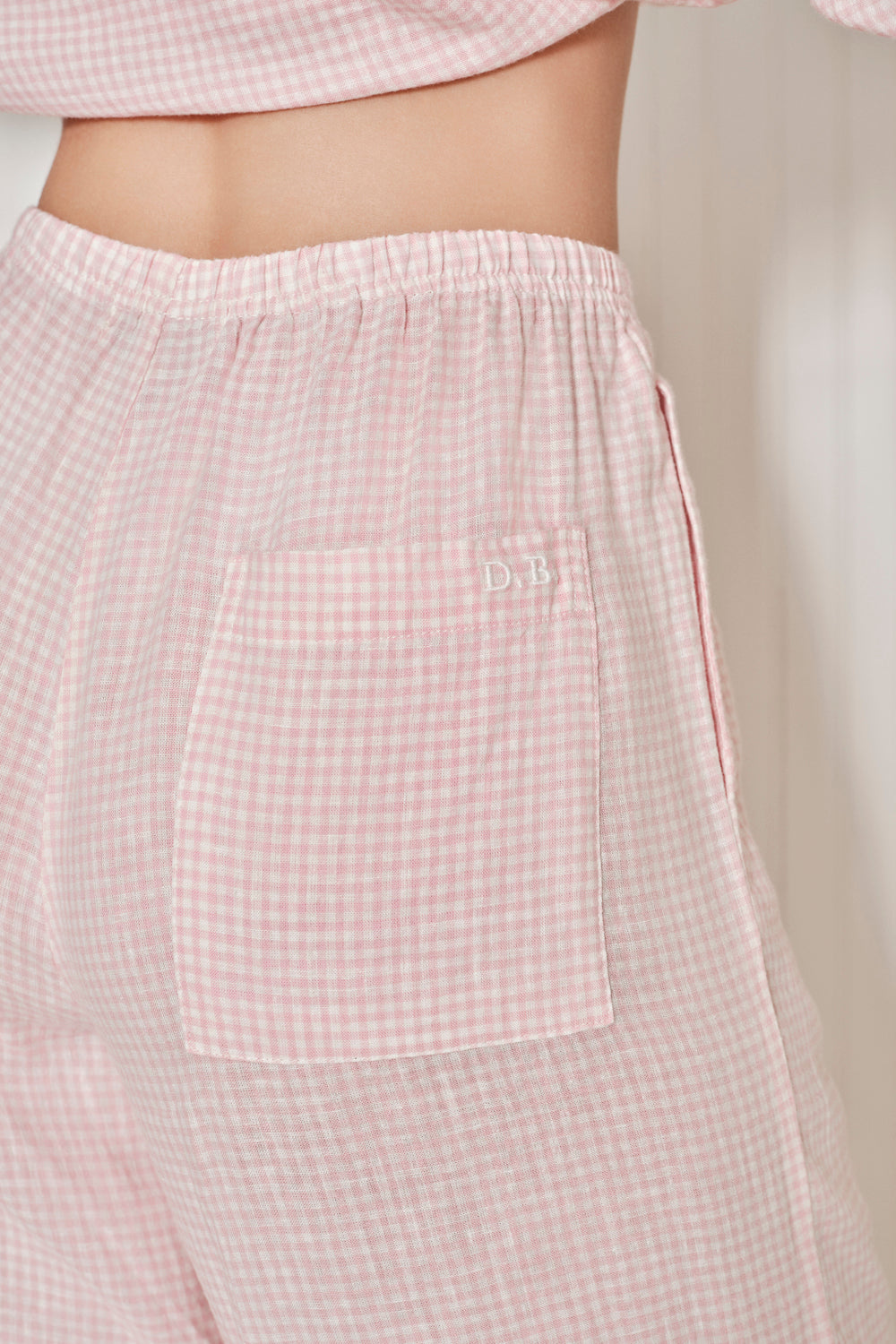 Pink checkered pants with a pocket on a neutral background. |M1