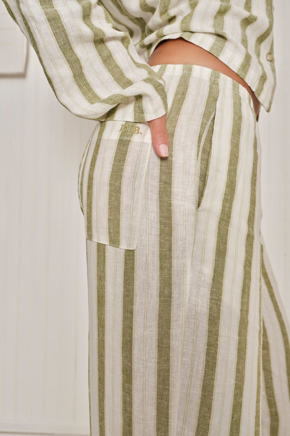 Person wearing a green and white striped pajama set with a neutral background. |M1