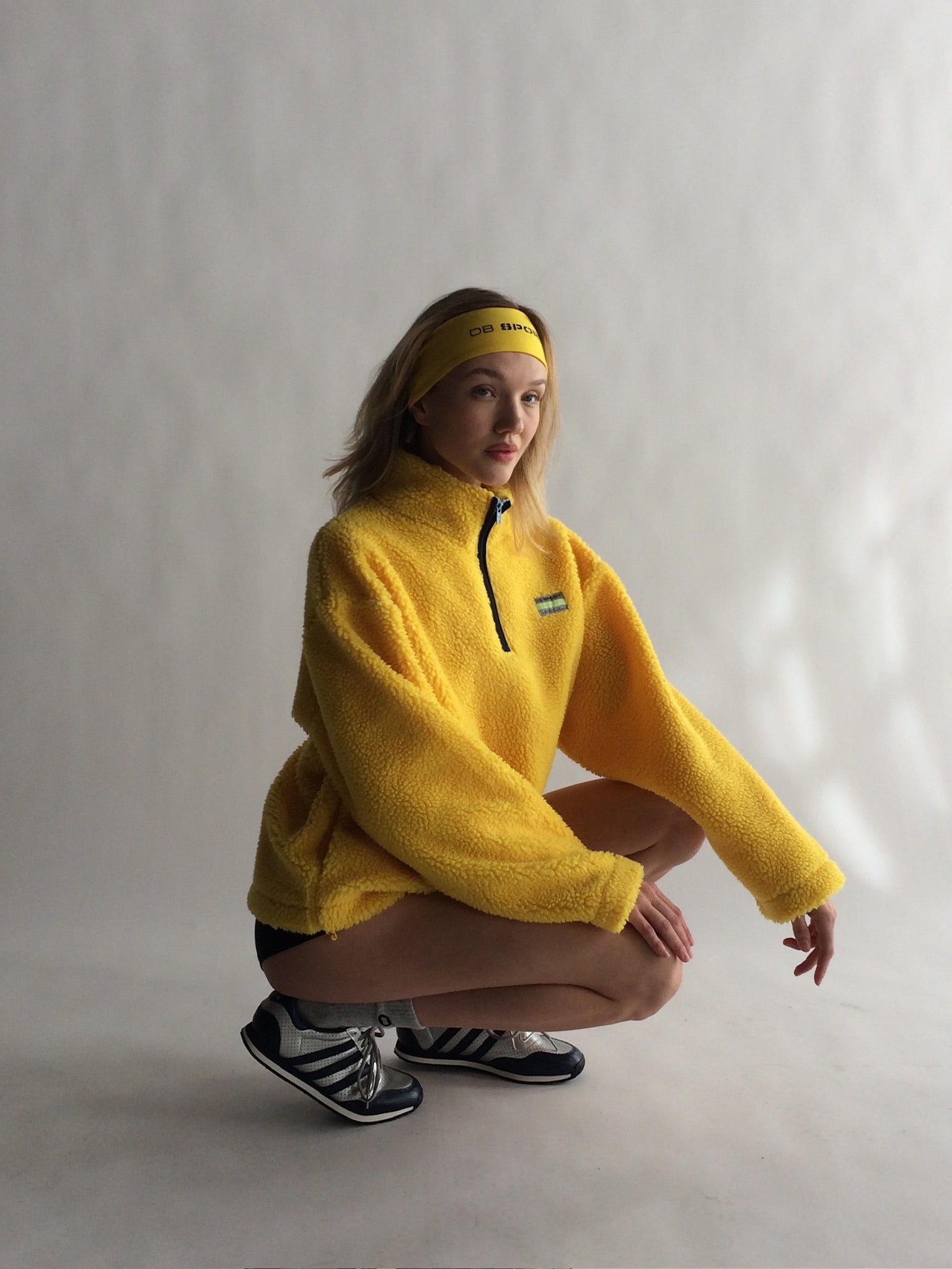 Person wearing a yellow fleece pullover and headband on a plain background |M1