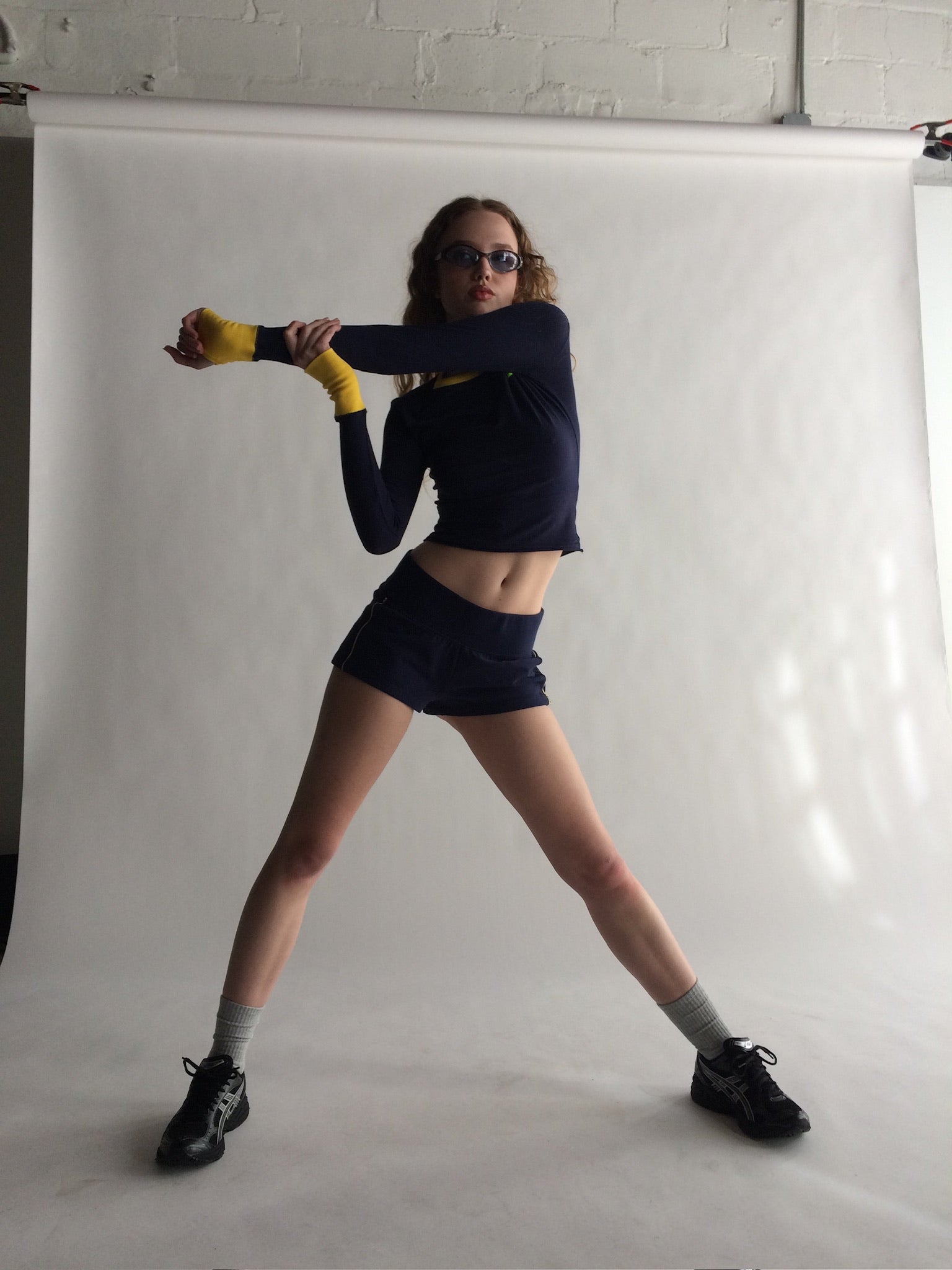Person posing in a studio setting with a white backdrop |M1