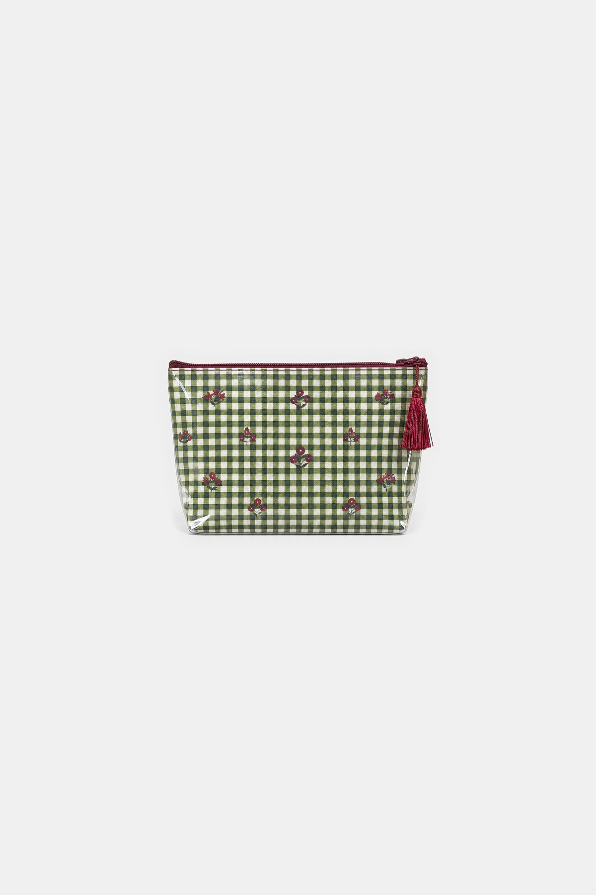 Front view of a zip makeup bag in green and white gingham with small red floral motifs, a clear edge and a red tassel.