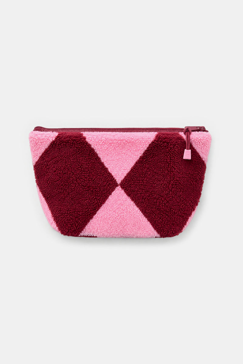 A small zippered pouch with a plush teddy texture, featuring a geometric diamond pattern in dark burgundy and light pink, set against a plain light gray background.