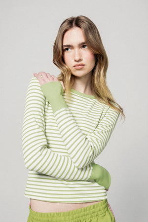Woman wearing a green and white striped sweater with matching pants against a plain background |m1