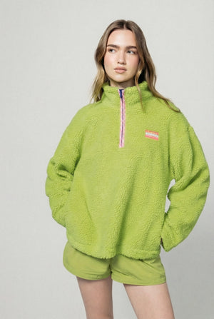 Person wearing a bright green fleece outfit with a small logo on a light gray background  |m1