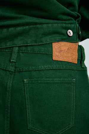 Close-up of green pants with a brand label on a gray background |m1