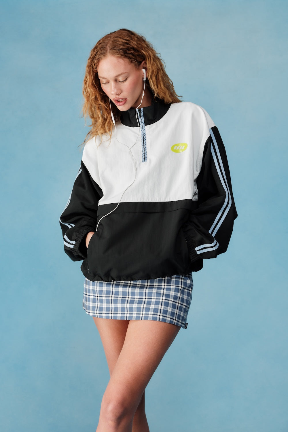 Woman wearing a black and white jacket with a plaid dress on a blue background |M1