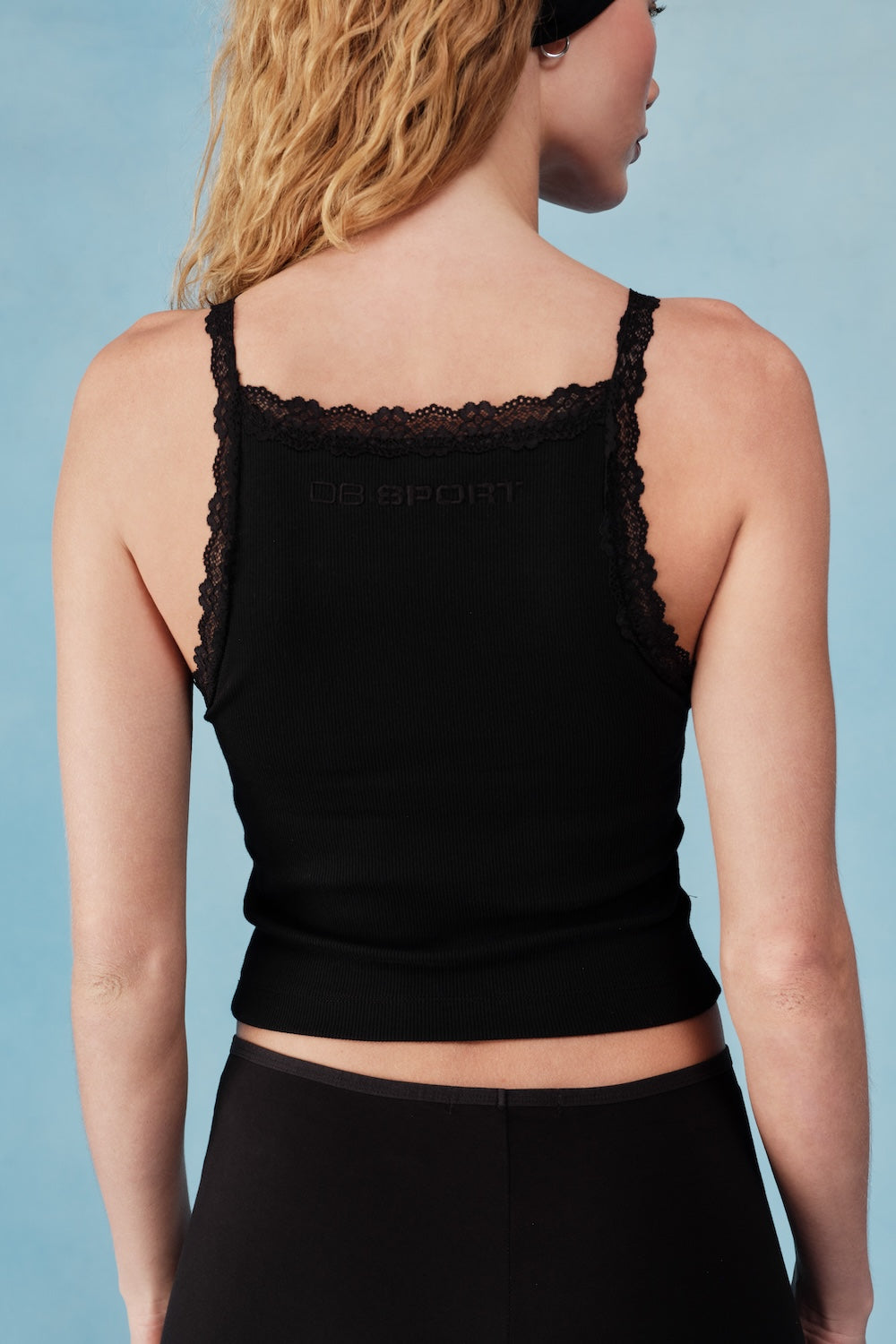 Black tank top with lace details on a plain background  |M1
