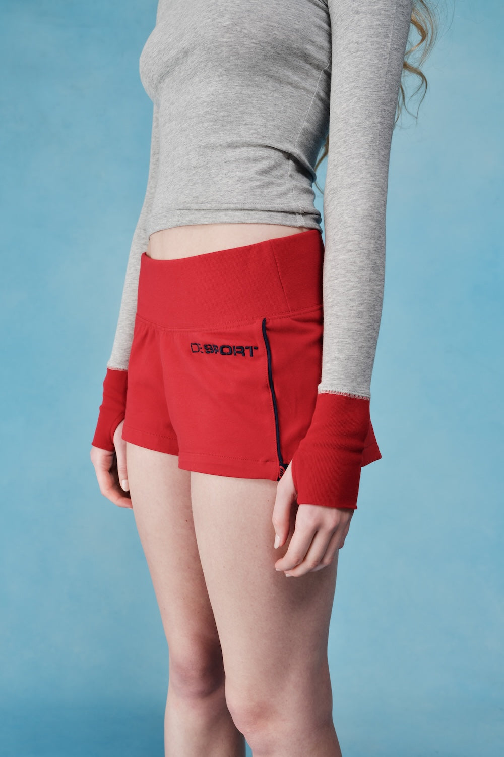 Red athletic shorts with a brand logo on a blue background  |M1