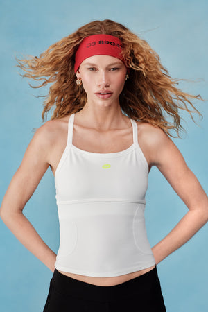 Woman wearing a white tank top and black shorts with a red headband against a light blue background F1F1F1 |M1