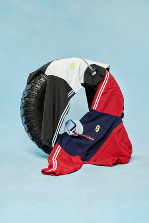 Red and navy jacket with a black tire on a light blue background