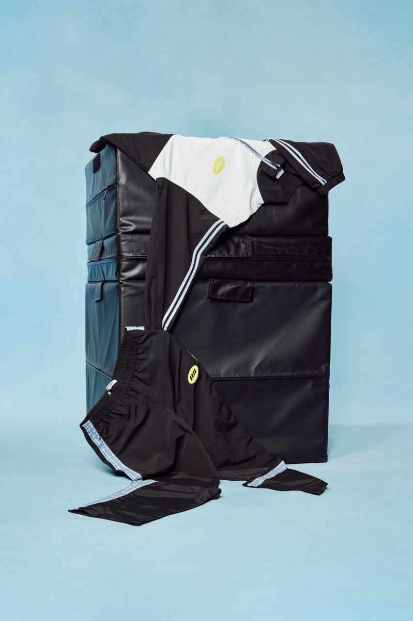 Black backpack with white trim on a light blue background