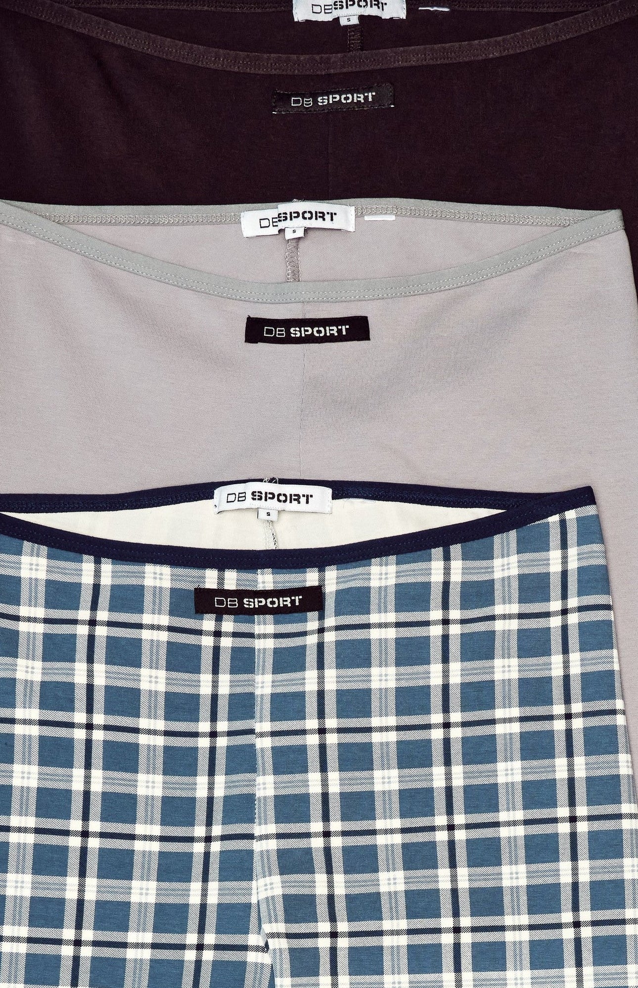 Three pairs of capris with visible brand labels on a white background