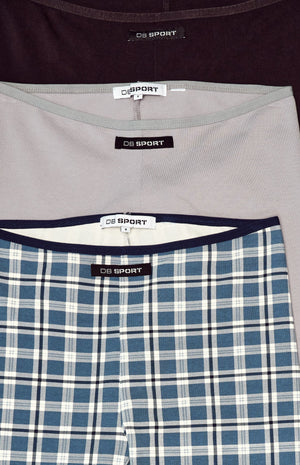 Three pairs of capris in plaid and solid colors on a light blue background