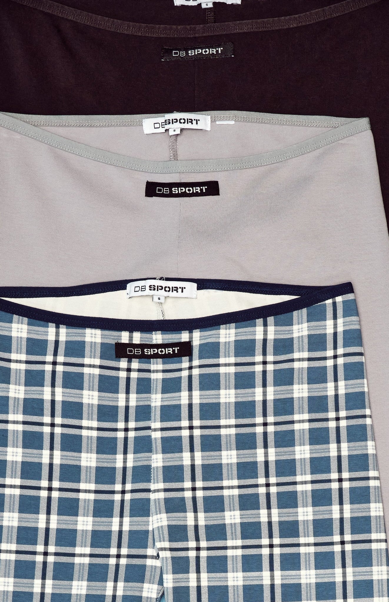 Close-up of capris with 'DB Sport' label on a plaid pattern