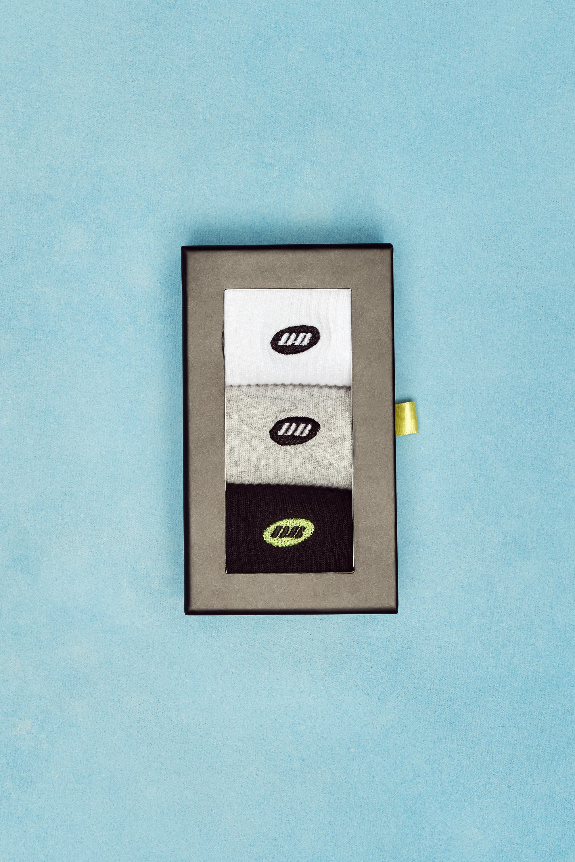 Set of socks in a box with a visible brand logo on a light blue background