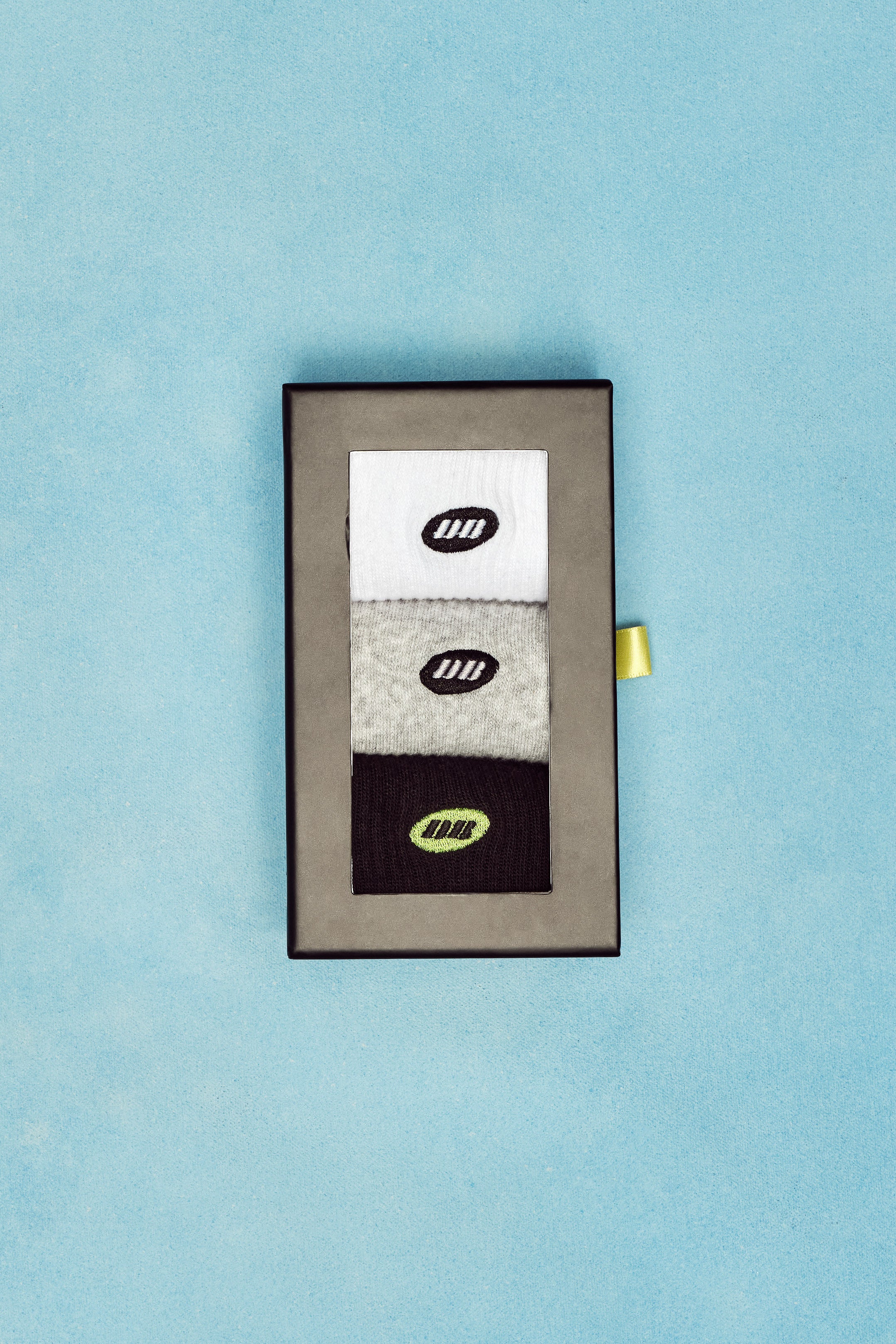 Set of socks in a box with a visible brand logo on a light blue background
