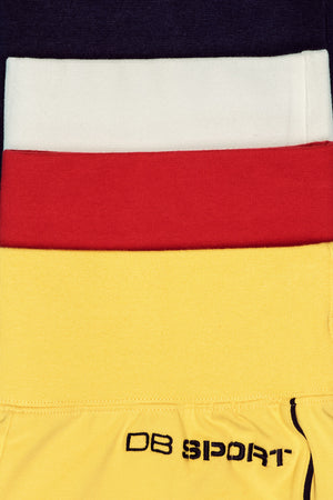 Close-up of a sport shorts with red, white, and yellow sections, featuring 'DB Sport' branding.