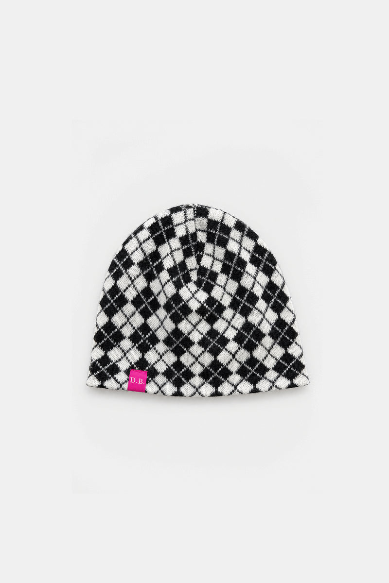 A black and white checkered knit beanie hat with a small pink tag on the lower left edge, displayed against a light gray background.