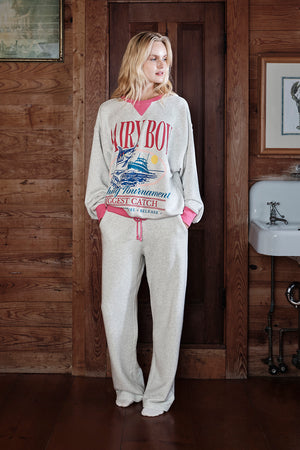 Person wearing a 'Dairy Boy' sweatshirt and pants in a rustic interior setting.
|M1