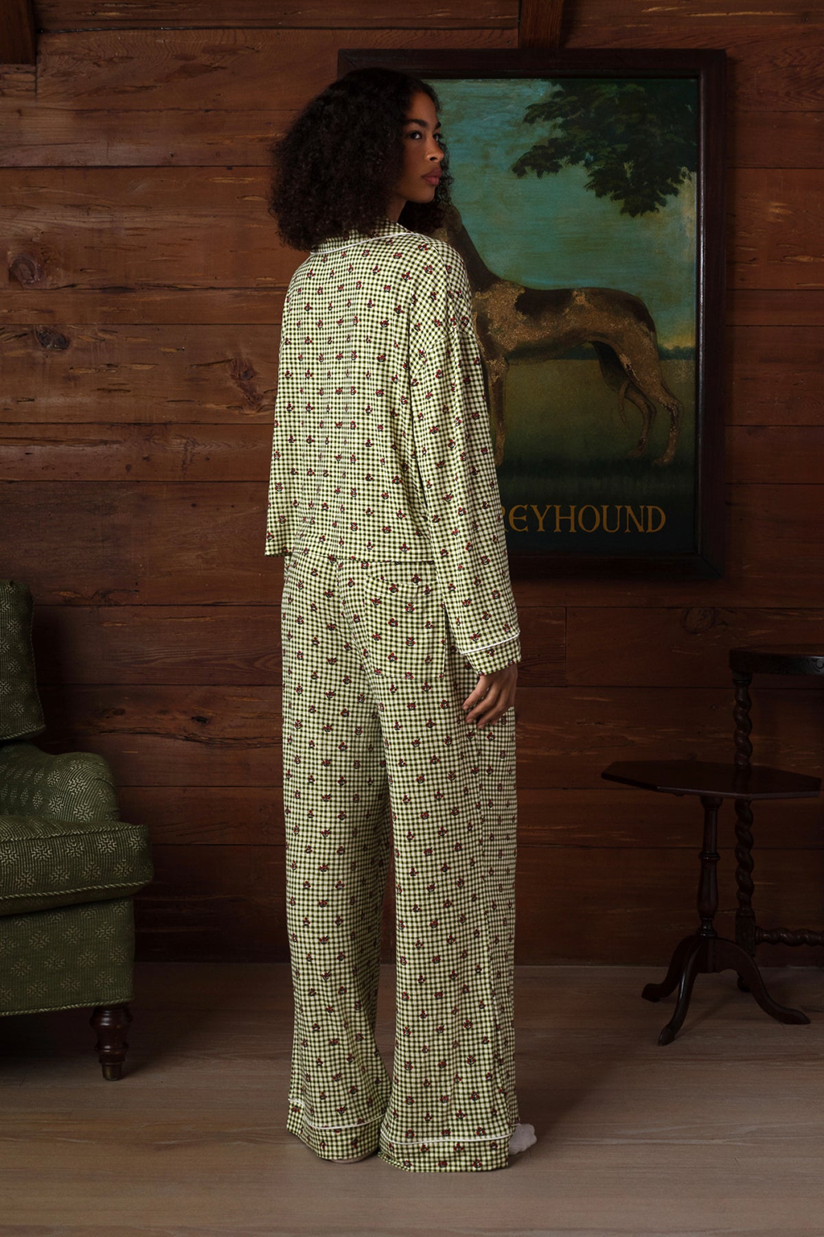 Back view on a model of a long-sleeve pajama set in green and cream gingham with a small red floral print, white piping and wide-leg pants. |M1