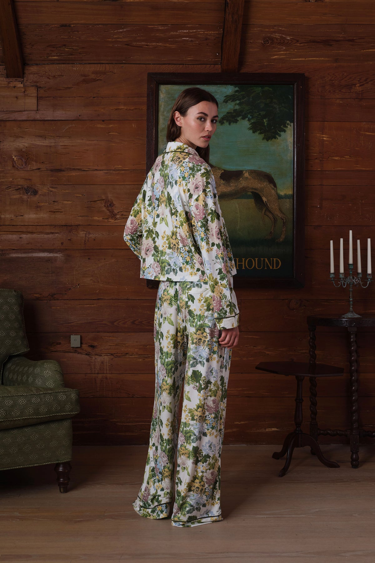 Back view on a model of a floral pajama set: long-sleeve collared top and wide-leg pants in green, pink, yellow and blue flowers with dark piping. |M2