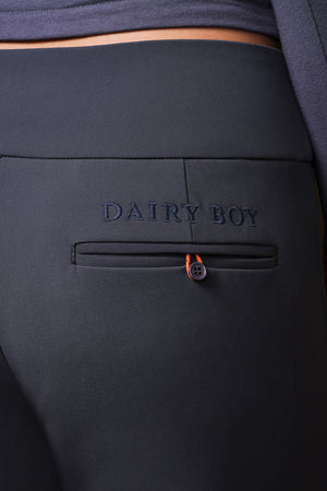 Close-up of dark charcoal gray pants featuring an embossed 'DAIRY BOY' logo on the back pocket, with a small orange accent near the pocket closure.
|M1