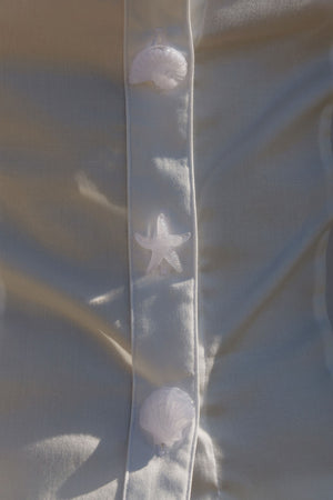 white button up with detailed image of shell buttons