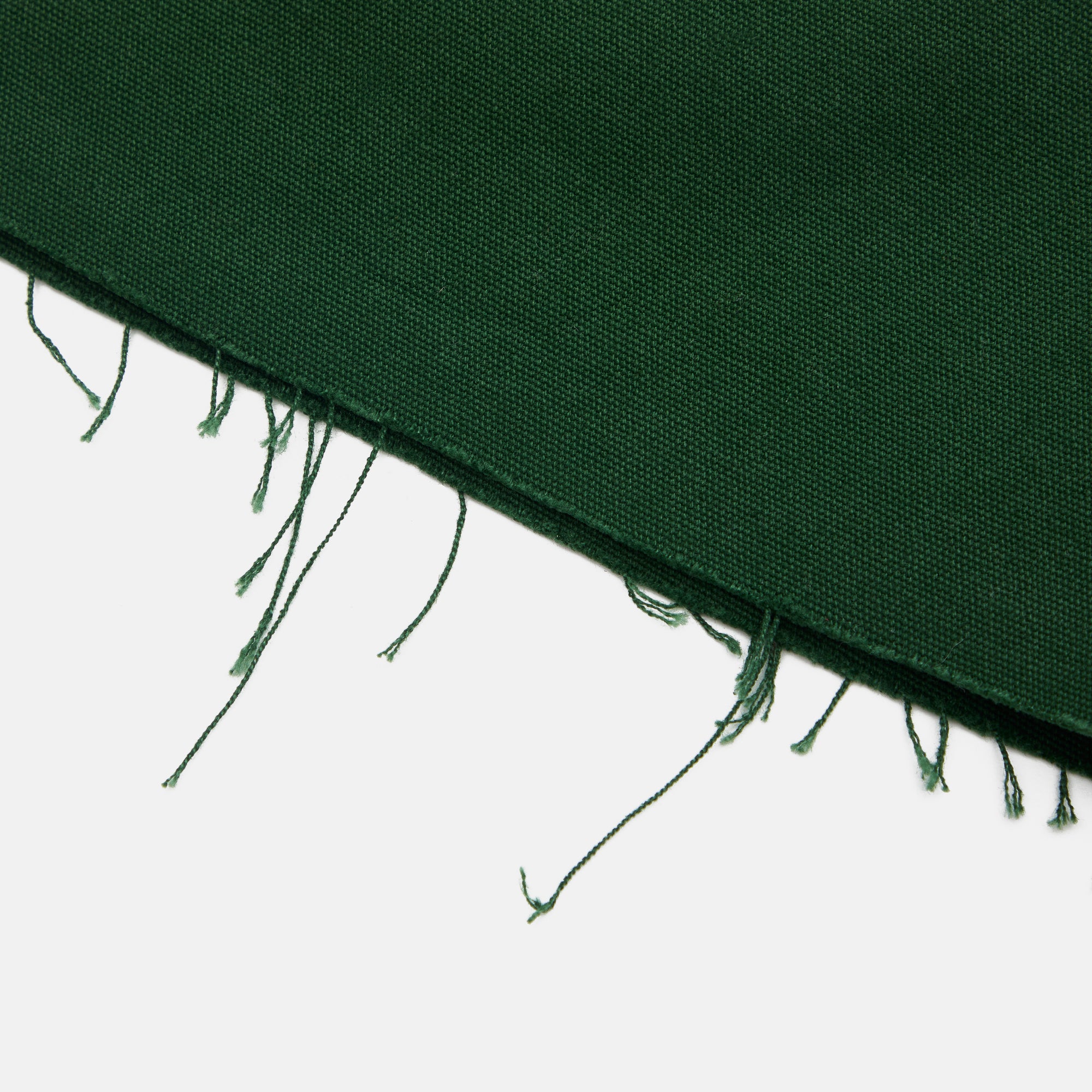 Dark green fabric with frayed edges on a white background