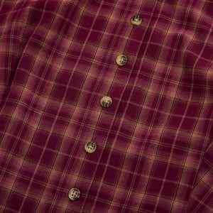 Close-up of a red and beige plaid dress front with buttons