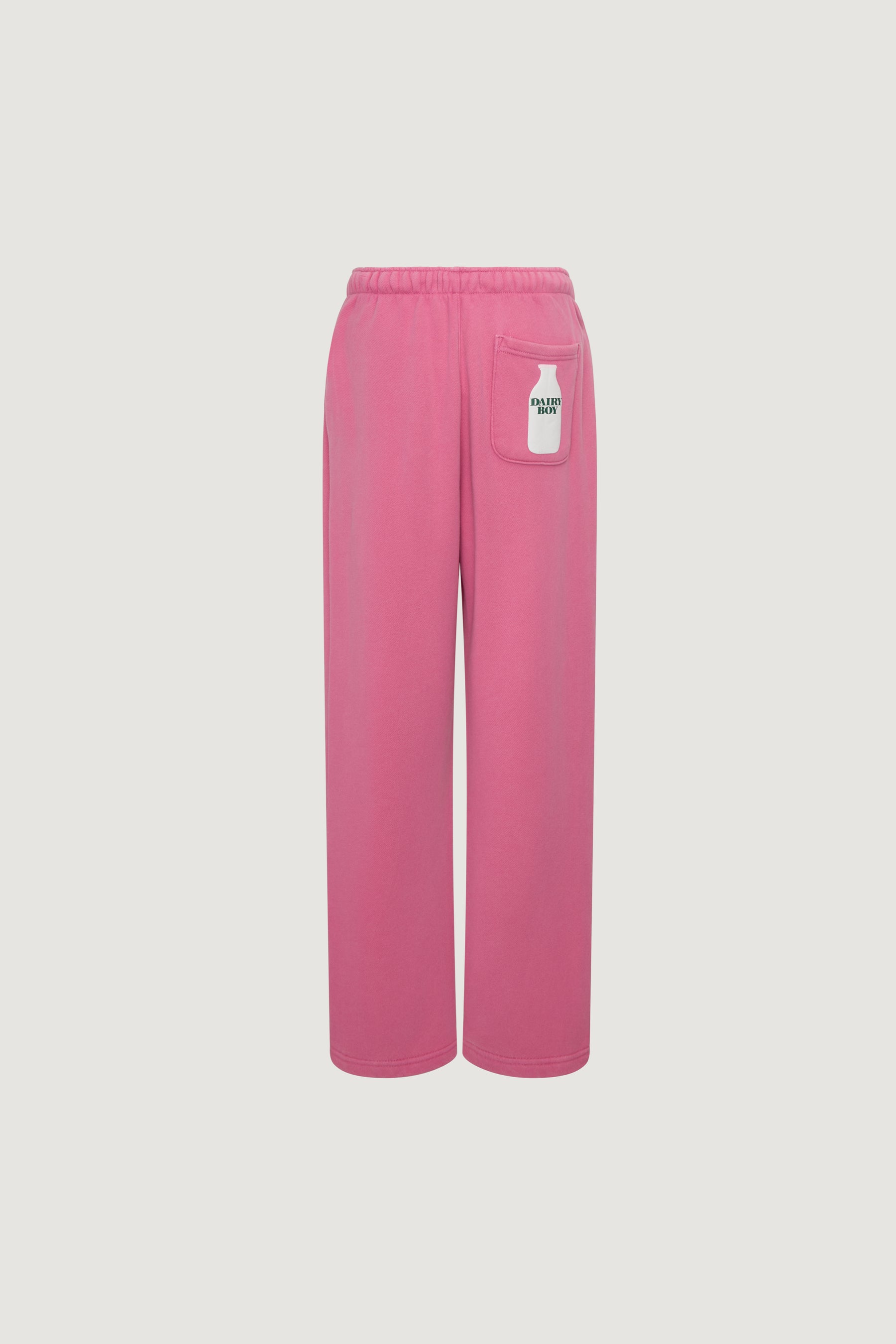 The Dairy Boy Milk Bottle Sweatpant in Strawberry Milk features wide legs, an elastic waistband, and a small white patch with "DAIRY BOY" on the back right pocket. Displayed on a plain white background.