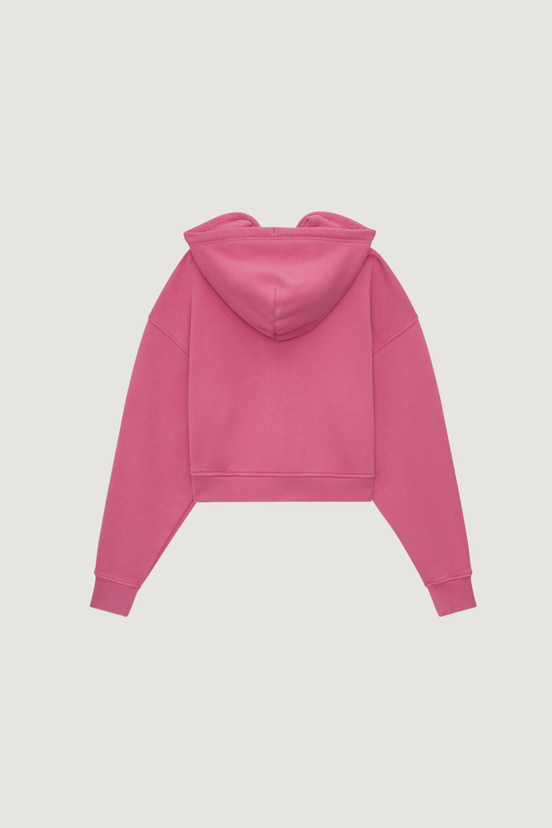 The Dairy Boy Milk Bottle Cropped Zip Up in Strawberry Milk is a bright pink cropped hoodie with long sleeves and a hood, shown flat from the back against a plain white background.