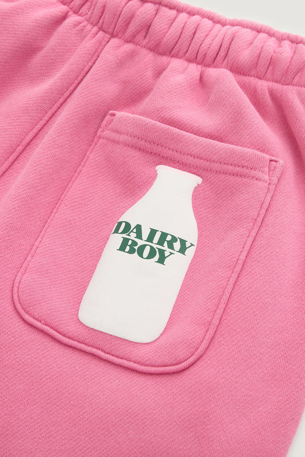 Close-up of the Dairy Boy Milk Bottle Sweatpant in Strawberry Milk, showing a soft, stretchy pocket with a white milk bottle graphic and "DAIRY BOY" in green text, plus visible stitching.
