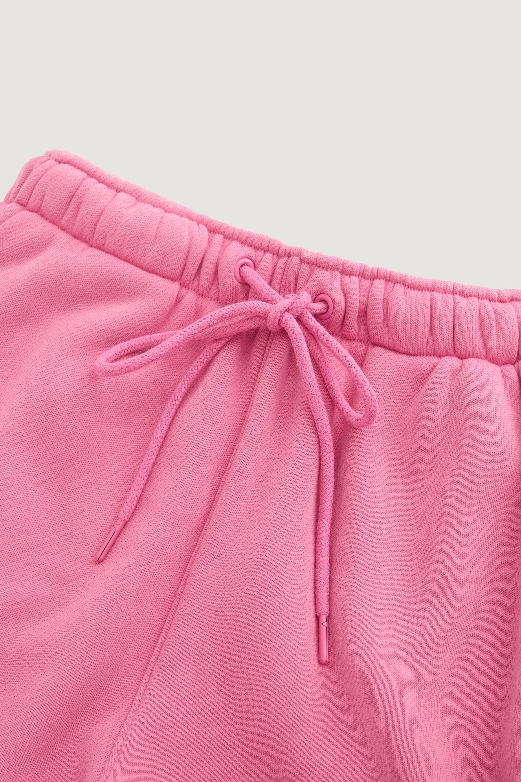 Close-up of the waistband on Dairy Boy’s Milk Bottle Sweatpant in Strawberry Milk, featuring an elastic band and a matching drawstring bow. The fabric looks soft and comfortable.